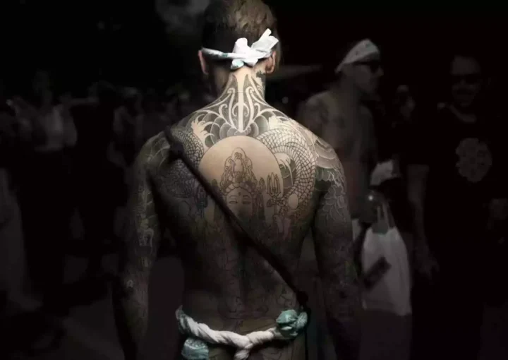 Large back tattoo featuring a central figure surrounded by detailed patterns