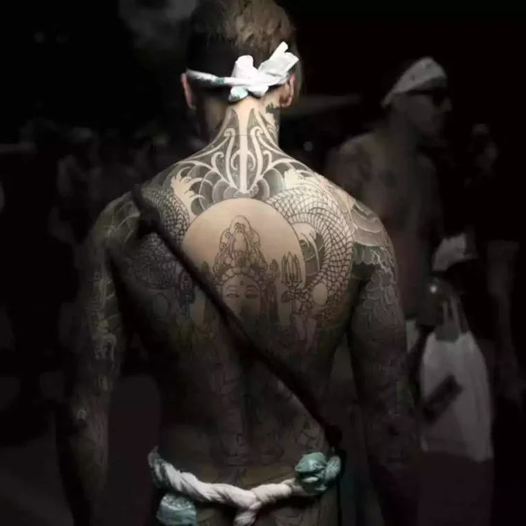 Large back tattoo featuring a central figure surrounded by detailed patterns