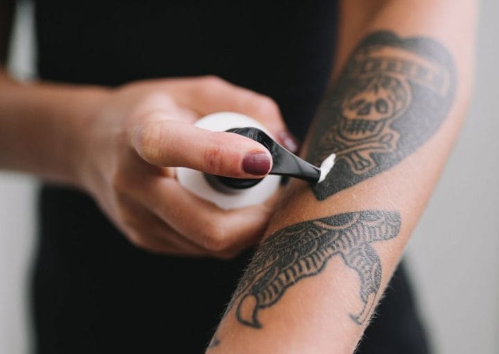 Applying cream to a tattooed forearm
